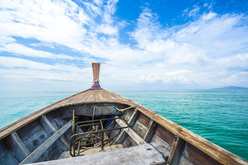 Traditional Thai wooden longtail boat heads out into the Andaman Sea on a day trip from Koh Phi Phi Island