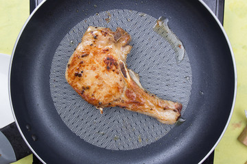 Chef cooking porkchop in frying pan