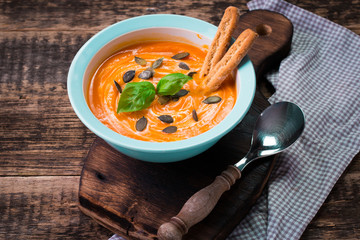 Roasted pumpkin and carrot soup with cream and pumpkin seeds