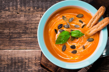 Roasted pumpkin and carrot soup with cream and pumpkin seeds