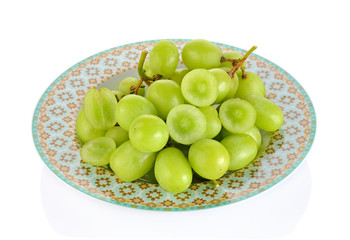 Seedless green grapes on a plate isolated on white background