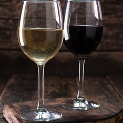 white and red glasses of wine on vintage wooden table