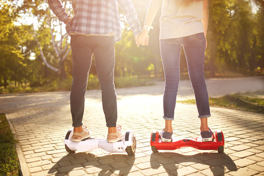 young man and woman riding on the Hoverboard in the park. content technologies. a new movement. Close Up of Dual Wheel Self Balancing Electric Skateboard Smart
