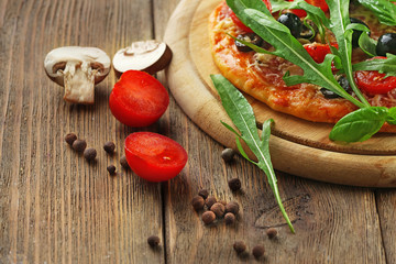 Tasty pizza with vegetables, herbs on wooden background