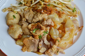 large noodle with pork ball dressing black sweet soy sauce on plate