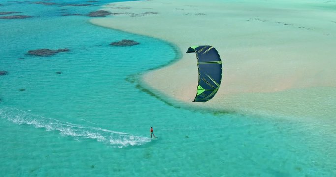 Aerial view young man kitesurfing in tropical blue ocean, extreme sport