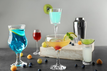 Delicious cocktails with sweet berries on gray table