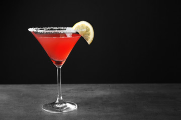Delicious cocktail with lemon slice on gray table