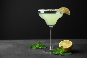 Delicious cocktail with lime slice and mint on gray table