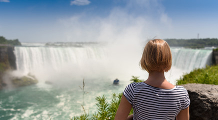 Young women looking at amazing Niagara falls. Canada Ontario