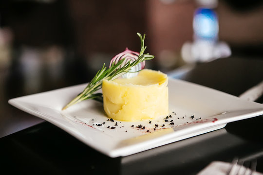 Mashed potatoes with rosemary in the form of a circle on a squar