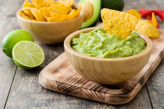 Nachos and guacamole on wooden background

