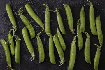 pods of green peas on a wooden table, rustic style,healthy food