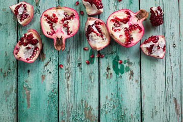 Fresh pomegranates in an old box with leaves. On wooden background.