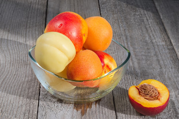 Vase with fruits on grey wooden background