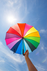 open colorful rainbow umbrella on blue sky background, vintage look