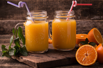 Naklejka na ściany i meble Citrus juice and fruits on wooden background.