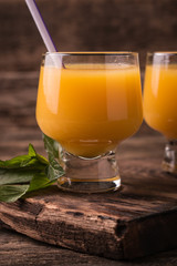 Citrus juice and fruits on wooden background.