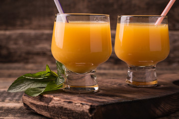 Citrus juice and fruits on wooden background.