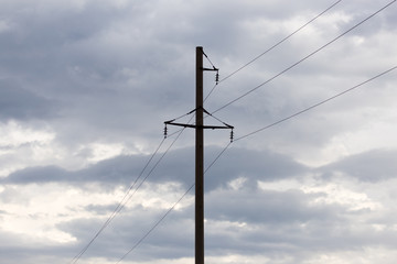 electric poles against the sky with clouds