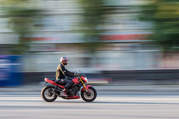 Naklejka premium Motocyklista w ruchu miejskim w rozmyciu ruchu