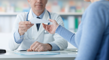 Doctor giving a medical prescription to the patient