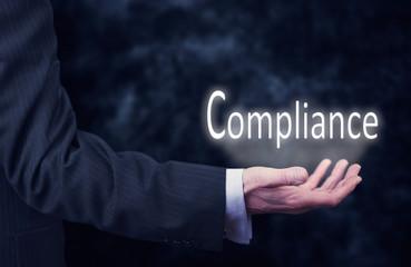 Businessman holding a Compliance Concept