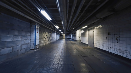 Smooth camera steady slide shot around old long extended industrial house tunnel basement, with grudge walls, rusty ripes, metal flour and broken lamps, perfect for or movie clips background