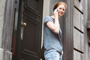 Fototapeta premium Woman on the Phone before a Building