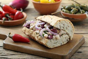 panino con tonno fagioli e cipolle  sfondo tavolo di cucina rustico