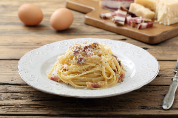 pasta carbonara  con uova carne e formaggio sfondo tavolo di cucina rustico - 122152377