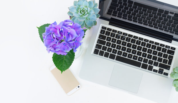 Laptop and phone on white table mock up flat lay scene, copy space on white table