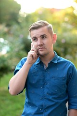 Obraz premium Young handsome hipster talking on the cellphone