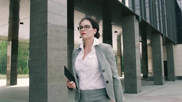Young business woman walking to the office building