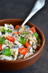 Holiday salad with mushrooms tomatoes and sauce on a black background.