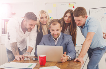 Happy business people team together near laptop in office