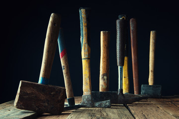 Many old hammers on wooden table