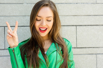 Beautiful smiling brunette woman showing a peace sign.