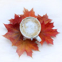 coffee with autumn mood/ flat lay with a cup of frothy cappuccino and maple leaves top view