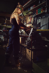 Obraz na płótnie Canvas Woman mechanic working in a motorcycle workshop