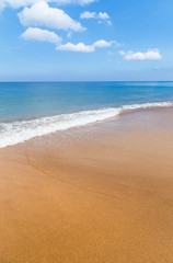 Fototapeta na wymiar white soft wave on tropical beach and blue sea with white cloud and blue sky background