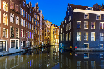 Naklejka premium Beautiful typical Dutch houses at the Amsterdam canal at night, Holland, Netherlands.