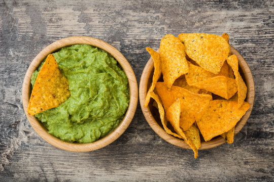 Guacamole with nachos on wooden background

