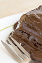 Chocolate cream on the cake with fork