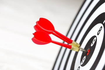 Target dart arrow hitting in the target center of dartboard