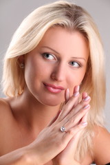 Beautiful young blonde shows off jewelry ring with stone