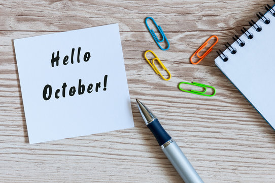Hello October on Paper Note at wooden texture workplace background. Autumn concept