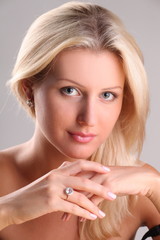 Beautiful young blonde shows off jewelry ring with stone
