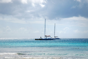 Obraz premium nice white pleasure sail boats catamaran in Caribbean sea , Dominican Republic