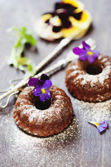 Delicious chocolate ring cake decorated with fresh violets